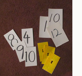 photo shows three sets of rectangular cards with numbers written with magic marker.  One set has the numbers written very small, another has larger numbers, and the third has very large letters written with thick lines.