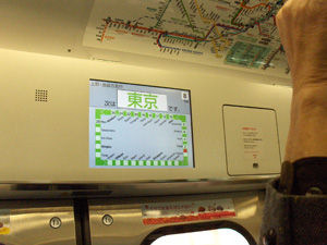 2 photos show a panel on the wall of the train car, with a rectangular line of about 25 dots representing 25 stations.  The Tokyo station is marked in red and has the number 2, the next 13 stations have increasing numbers up to 29.