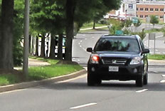 6 photos show a car and a bus approaching from where the street disappears. The car stays in the nearest lane so we never lose sight of it, but the bus is in the farthest lane and it disappears behind the trees, then appears again when it is about 50 feet from us.
