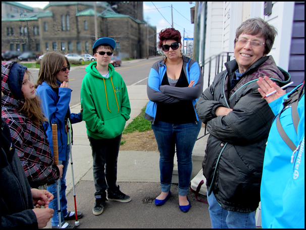 Both of these photos show the students and instructors standing in a circle near the street where the videos were taken, talking about their experience.