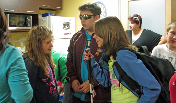 These 5 photos show the students greeting each other, sitting and standing around the conference table talking, and huddled together for a group hug.