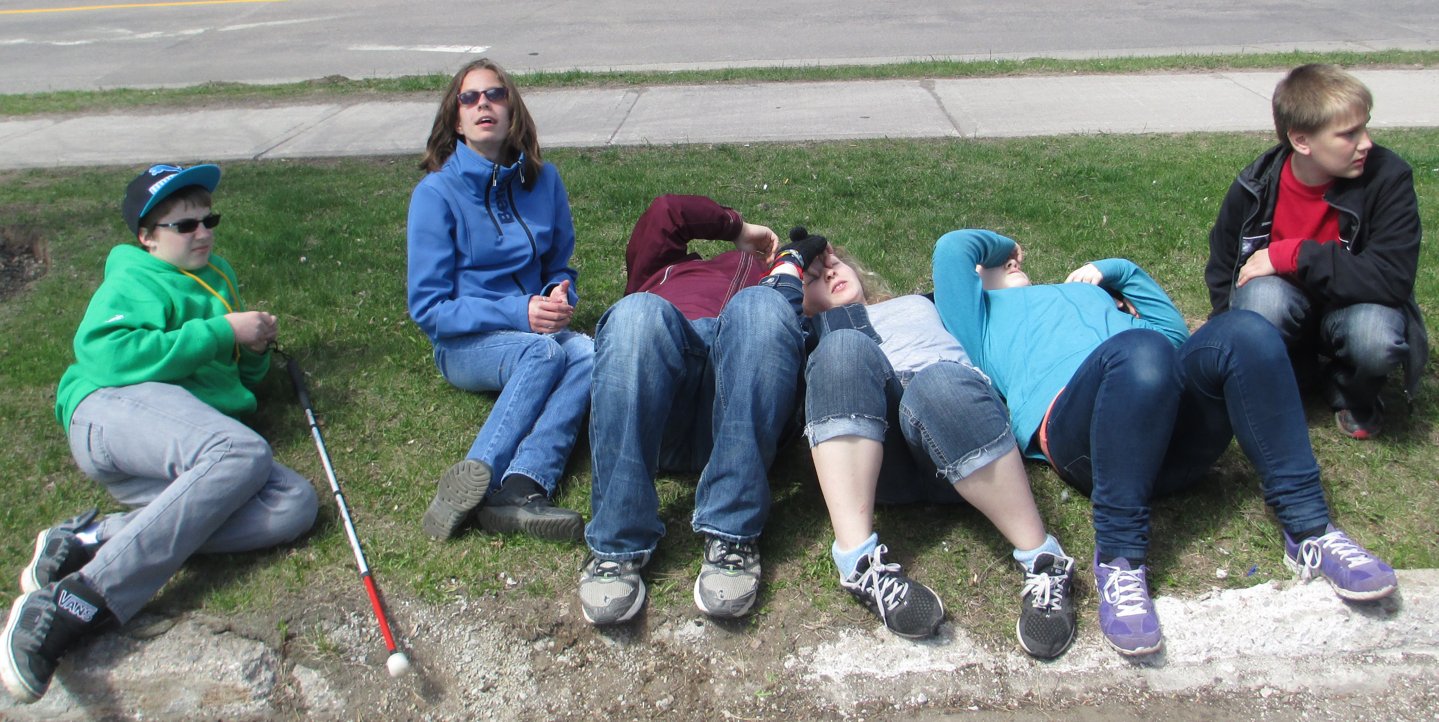 Both photos show the students sitting or lying on the grass and talking quietly.