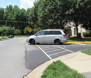 3 photos each show a car across the crosswalk -- the first is entering the far side of the side street, the second is coming out of the side street, and the third is going into the near side of the side street.