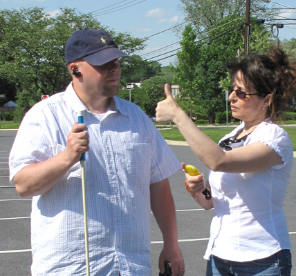 Photo shows instructor holding her stopwatch and giving student a 'thumbs-up' sign.
