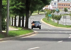 6 photos show a car and a bus approaching from where the street disappears.  The car stays in the nearest lane so we never lose sight of it, but the bus is in the farthest lane and it disappears behind the trees, then appears again when it is about 50 feet from us.