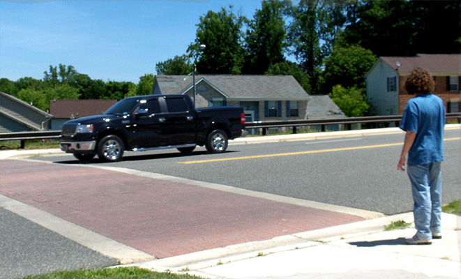 Photo shows the dark truck has reached the crosswalk.